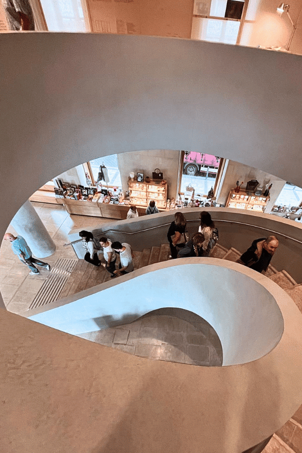 Escalera curva del interior de Faro Santander con visitantes recorriendo el edificio