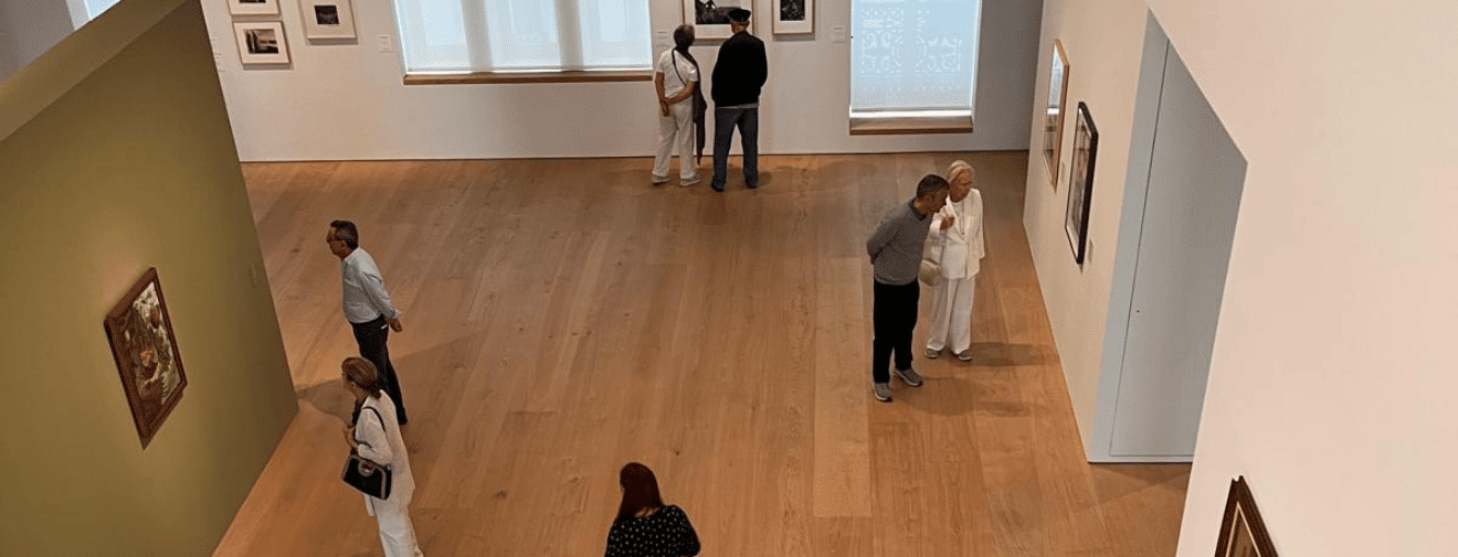 Grupo de visitantes observando obras de arte durante una visita a una exposición de Faro Santander.